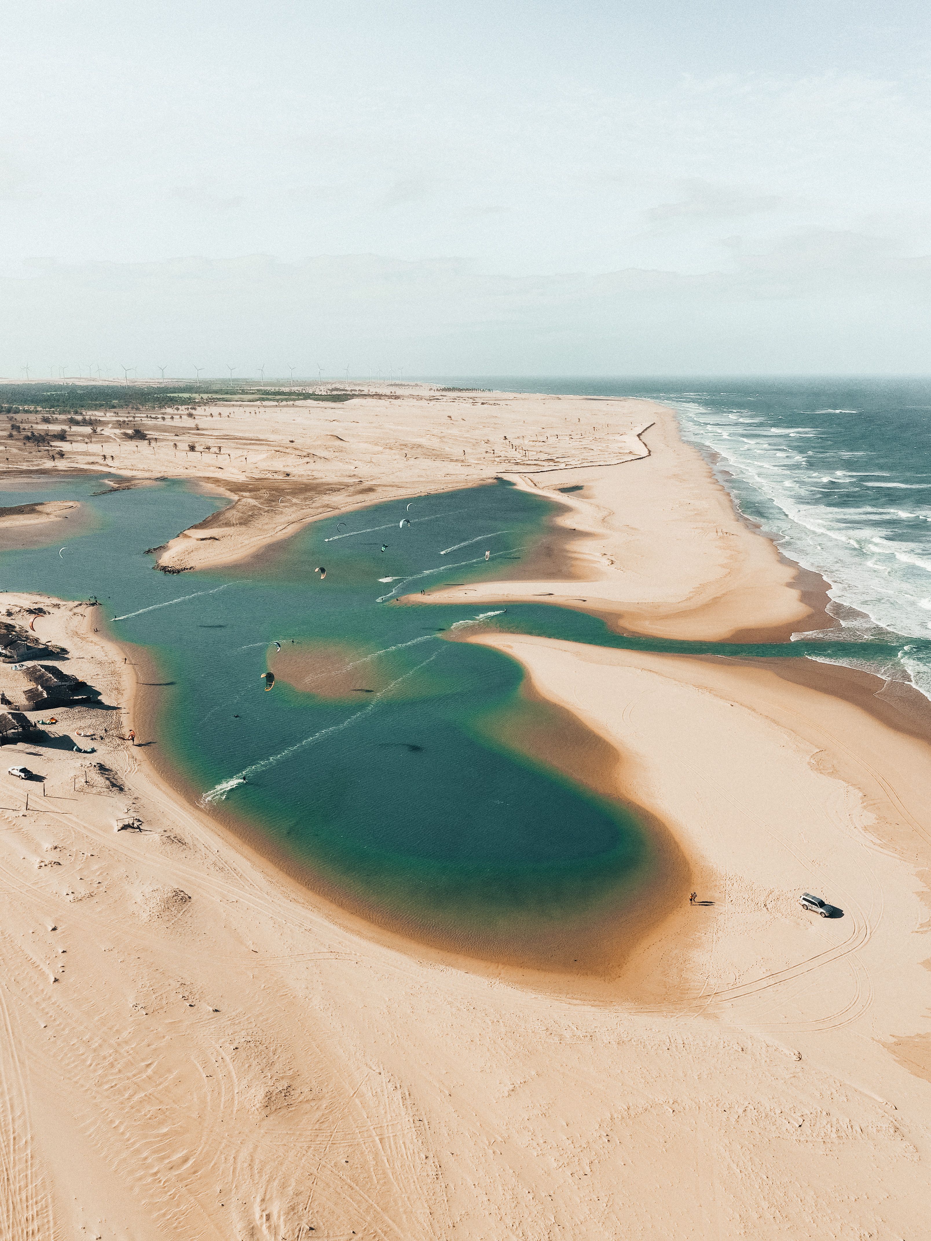 Dune Blanche — white sand dune rising above the turquoise Dakhla lagoon with blue kites overhead